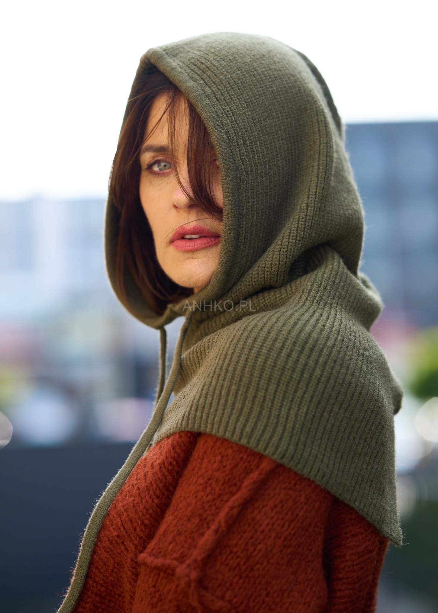 Dzianinowy kaptur damski w kolorze khaki z troczkami, wykonany z miękkiego materiału, idealny dodatek jesienno-zimowy