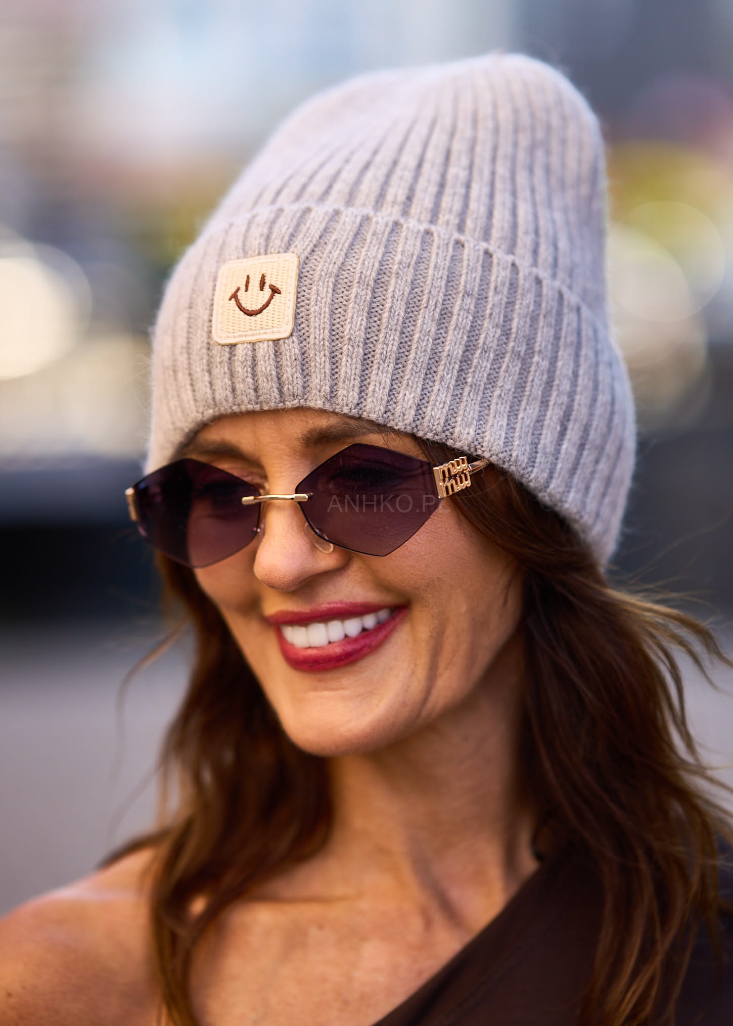 Jasnoszara czapka damska beanie z naszywką uśmiechu, wykonana z prążkowanej dzianiny, idealna do zimowych stylizacji