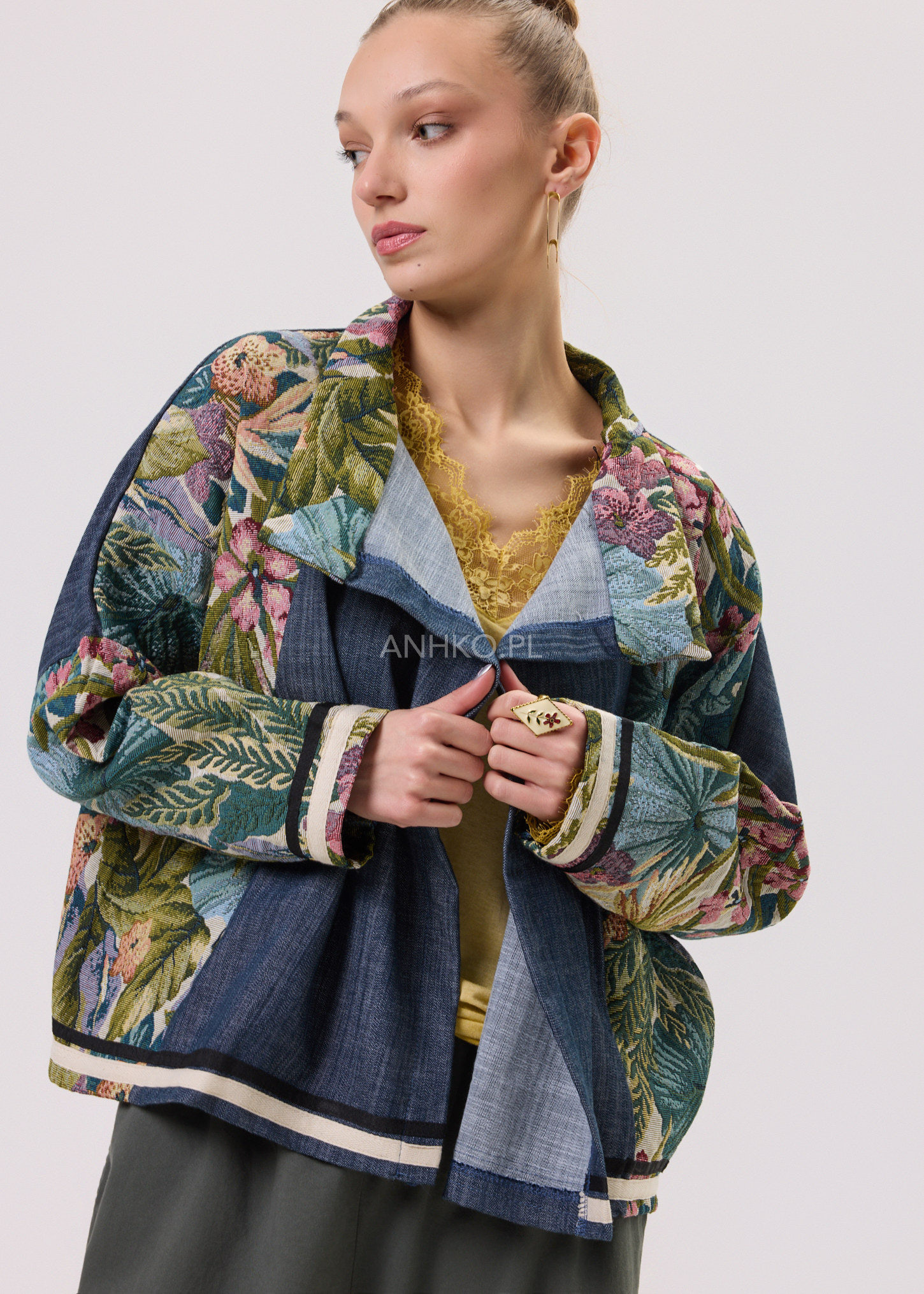 Kobieta w granatowej kurtce damskiej o luźnym kroju z dekoracyjnym kwiatowym wzorem