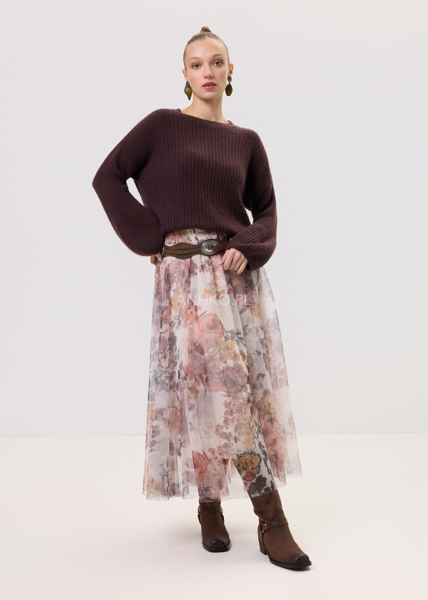 Kobieta w stylizacji na okres przejściowy z burgundowym swetrem damskim i plisowaną spódnicą midi