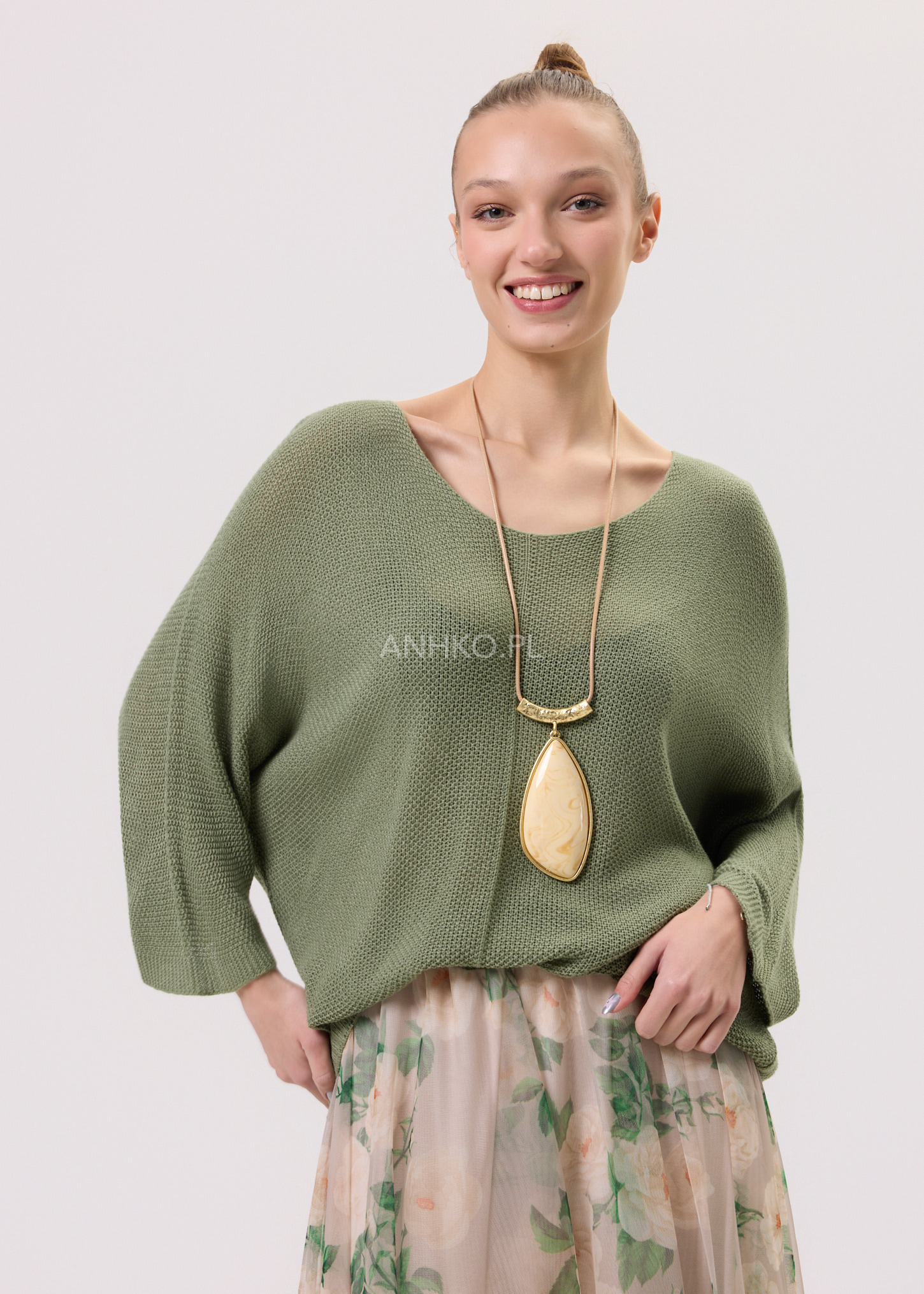 Kobieta w zielonej bluzce damskiej o luźnym kroju w stylizacji wiosennej