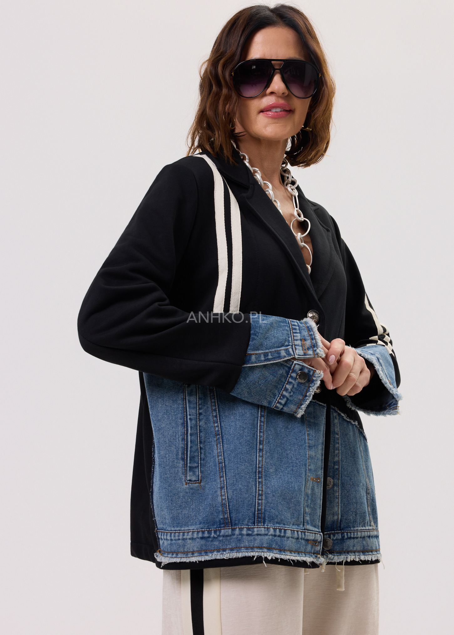 Kobieta w czarnej marynarce damskiej z jeansowym dołem w stylizacji casual na sezon przejściowy